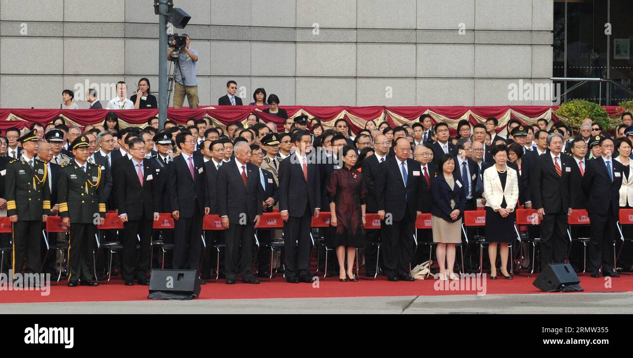(141001) -- HONG KONG, 1 de octubre de 2014 -- Tung Chee-hwa (5º Frente Izquierdo), vicepresidente de la Conferencia Consultiva Política del Comité Nacional del Pueblo Chino y ex presidente ejecutivo de Hong Kong, Leung Chun-ying (6º Frente Izquierdo), Zhang Xiaoming (4º Frente Izquierdo), Director de la Oficina de Enlace del Gobierno Popular Central en Hong Kong, y Song Zhe (3º L, Front), comisionado del Ministerio de Relaciones Exteriores de China en la Región Administrativa Especial de Hong Kong (SAR), asisten a una ceremonia de izamiento de la bandera que conmemora el 65º aniversario de la fundación del Peo Foto de stock