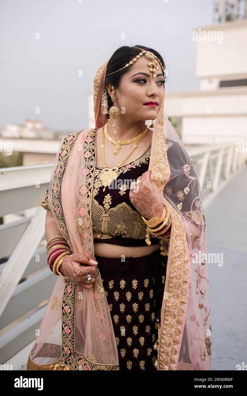 Una hermosa novia nepalí en el día de su boda, luciendo hermosa y feliz en su hermosa lehenga choli y maquillaje. Foto de stock