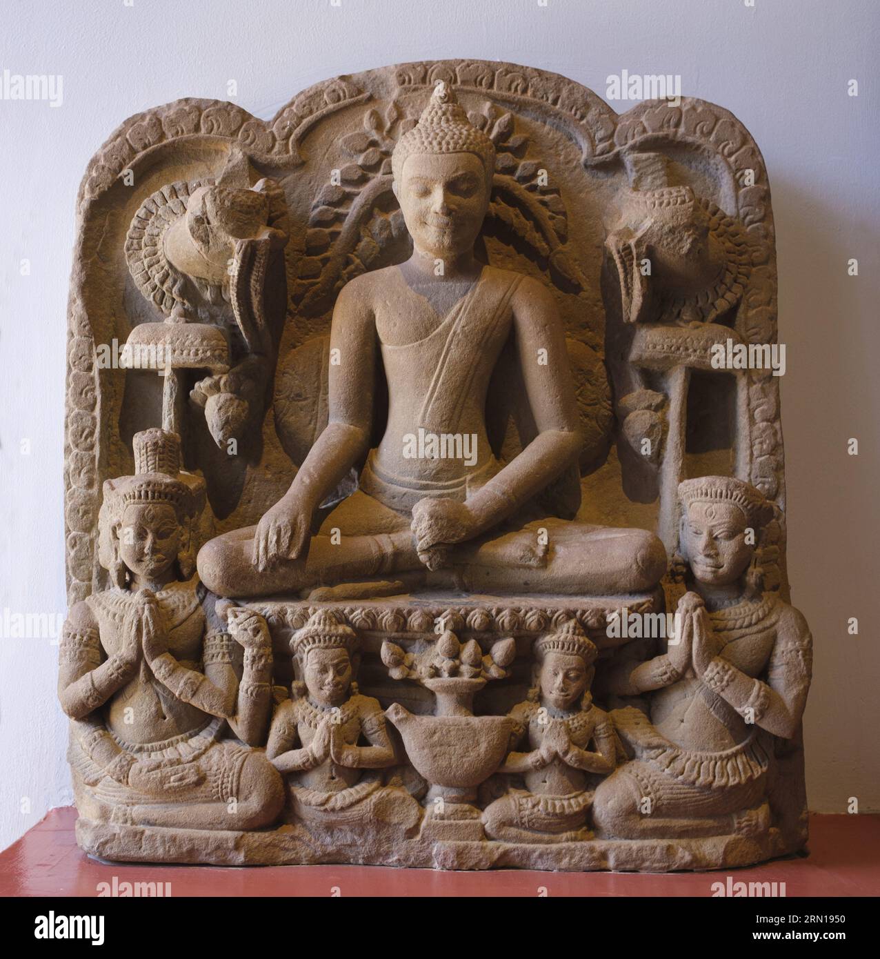 Camboya: Un bajorrelieve de piedra arenisca del siglo XIII del Buda y los adoradores, originario del Bayon, Angkor Thom, ahora en el Museo Nacional de Camboya, Phnom Penh. El Museo Nacional, ubicado en un pabellón rojo construido en 1918, alberga una colección de arte jemer que incluye algunas de las mejores piezas existentes. Las exposiciones incluyen una estatua de Vishnu del siglo VI, una estatua de Shiva del siglo IX y la famosa cabeza esculpida de Jayavarman VII en pose meditativa. Particularmente impresionante es un busto dañado de un Vishnu reclinado que una vez fue parte de una estatua de bronce masiva encontrada en el oeste de Mebon. Foto de stock