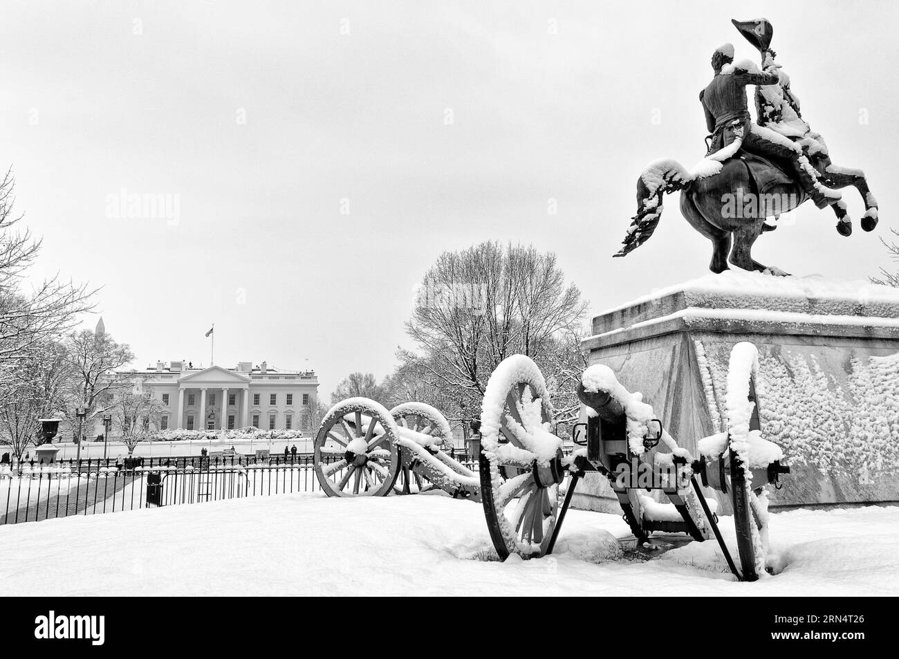 WASHINGTON DC, EE.UU. - Una estatua del Presidente Andrew Jackson, rodeada de cañones, en Lafayette Park cubierta de nieve fresca. En el fondo, a la izquierda Foto de stock