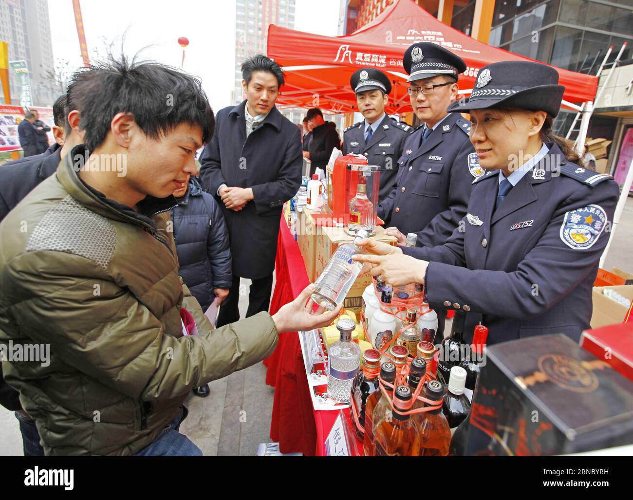 (160315) -- TENGZHOU, 15 de marzo de 2016 -- Los oficiales de policía dicen a los residentes locales cómo identificar el alcohol genuino y falsificado en Tengzhou, provincia de Shandong, al este de China, 15 de marzo de 2016. Se llevaron a cabo una variedad de actividades en toda China para concienciar a los consumidores sobre la protección de sus derechos cuando el Día Internacional de los Derechos del Consumidor cayó el 15 de marzo. ) (Wjq) CHINA-DÍA DE DERECHOS DEL CONSUMIDOR-ACTIVIDADES (CN) SongxHaicun PUBLICATIONxNOTxINxCHN Tengzhou 15 2016 de marzo Los oficiales de policía dicen a los residentes locales Cómo identificar el alcohol genuino y forjado en la provincia de Tengzhou Este de China S Shan Dong 15 2016 de marzo A VA Foto de stock