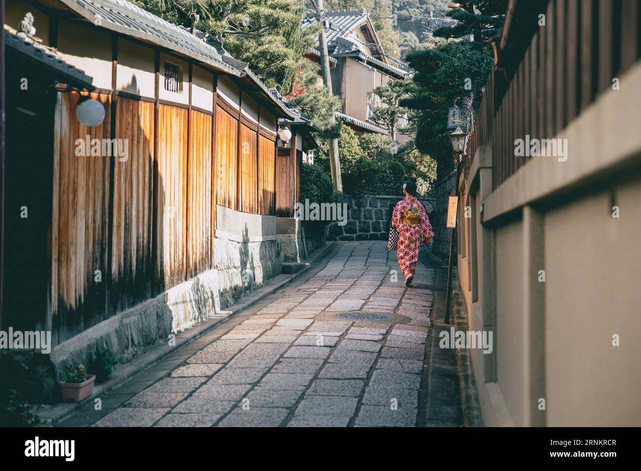 Callejón tranquilo en el distrito de Kioto Gion con una mujer Kimono japonesa caminando, estilo de vida antiguo de Japón Foto de stock