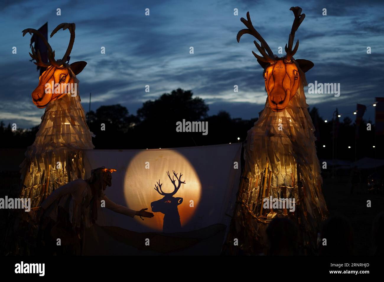 los títeres abstractos del cuerpo flanquean un espectáculo de la silueta en la luz de la noche Foto de stock