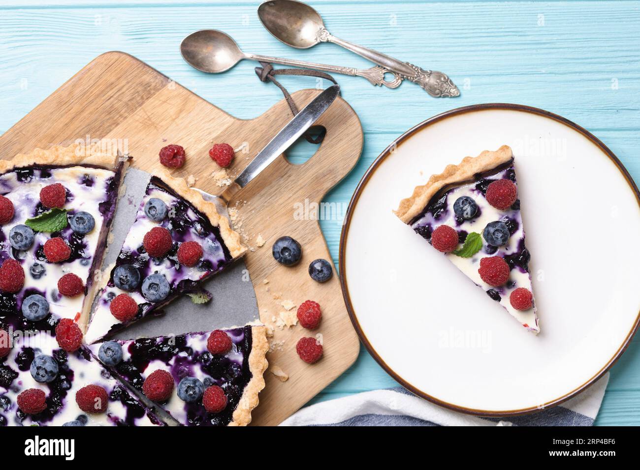 pastel de bayas con frambuesas y arándanos sobre un fondo azul Foto de stock