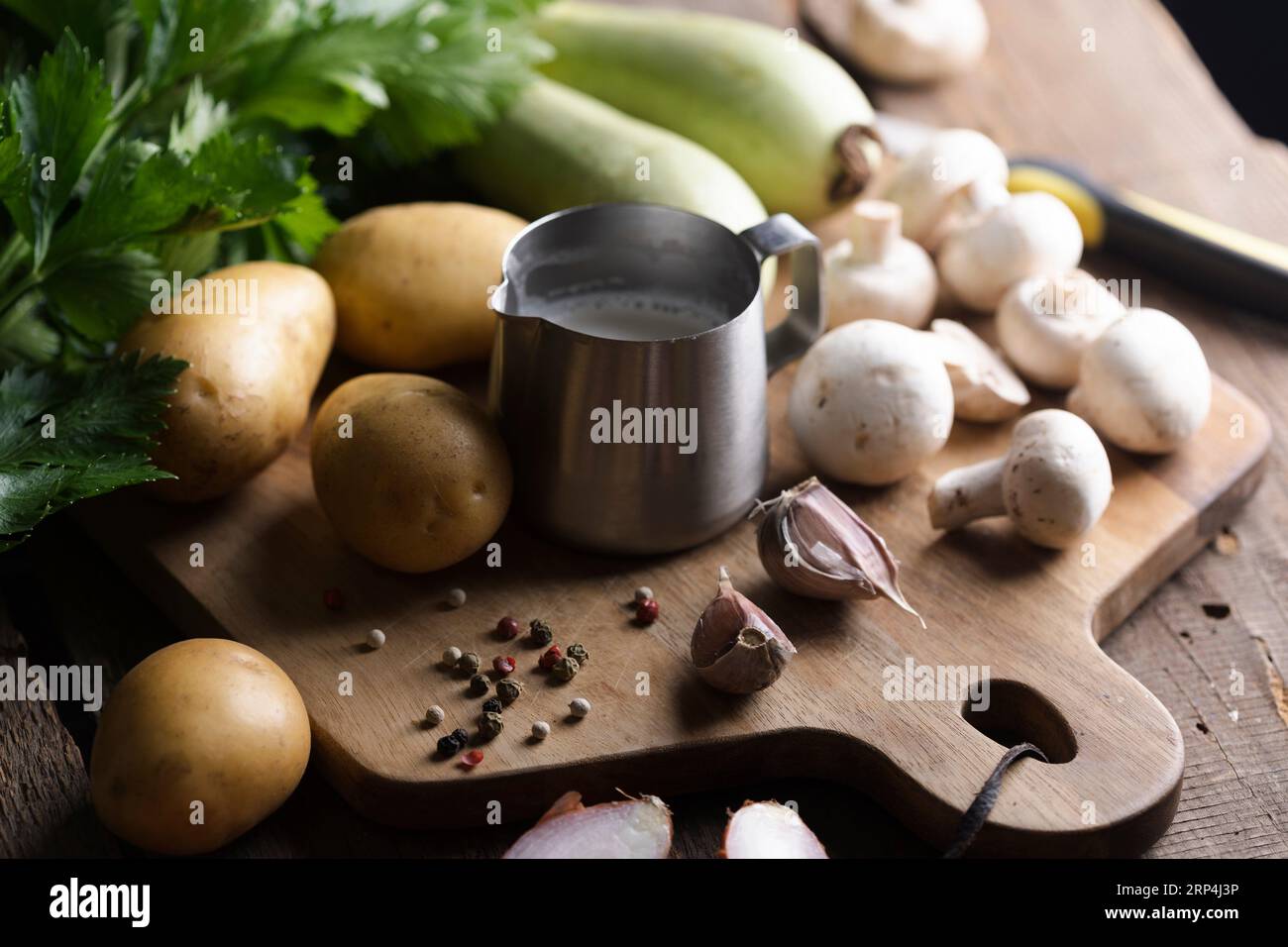 ingredientes para la sopa en una mesa de madera - patatas, crema, calabacín, cebolla, apio Foto de stock