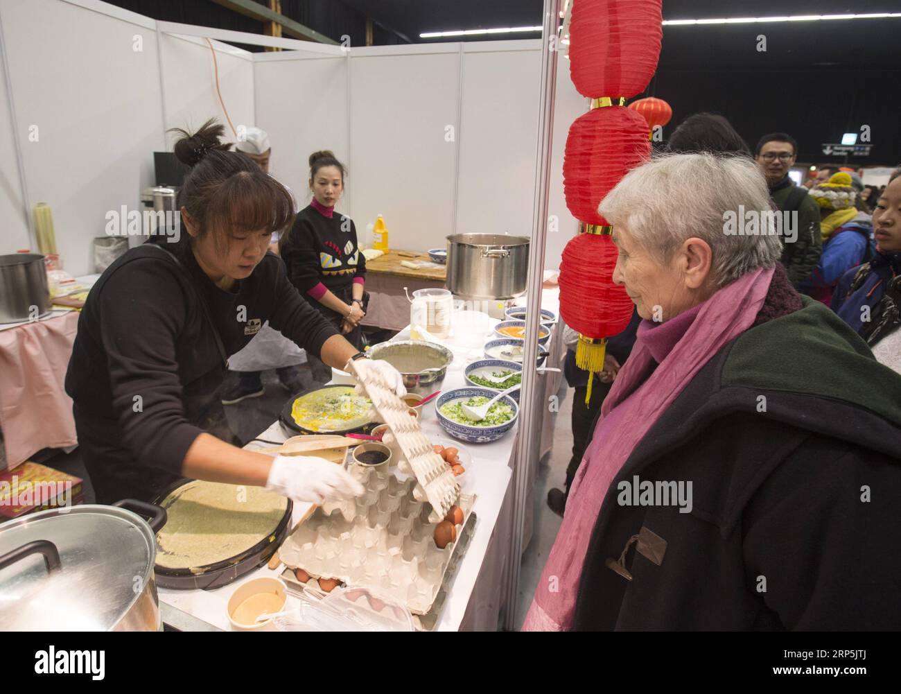 (181216) - BERNA, 16 de diciembre de 2018 -- Una mujer local espera para probar crepe chino durante el Festival de la Cultura de la Comida China en Berna, capital de Suiza, el 16 de diciembre de 2018. El domingo se celebró el primer Festival de la Cultura Alimentaria China en el interior de Bernexpo, en la capital suiza, que atrajo a más de 1.000 residentes locales en la temporada festiva de Navidad. Los visitantes disfrutaron de aperitivos chinos, así como de actuaciones tradicionales como caligrafía, canciones populares y artes marciales, durante el festival de un día apoyado por la Embajada de China y patrocinado por varias asociaciones locales. SUIZA-BERNA-CHINA Foto de stock