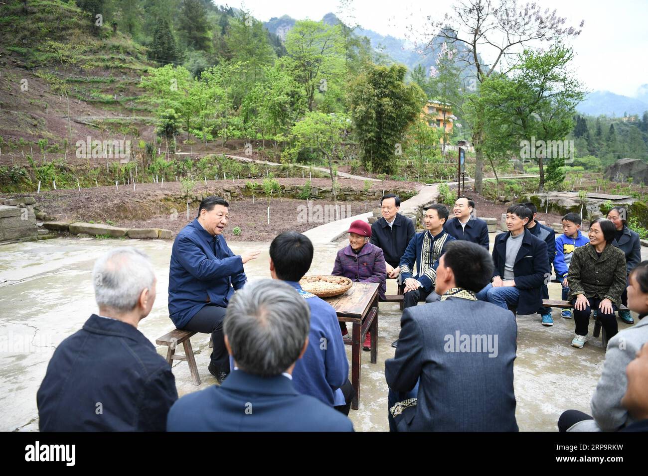 (190415) -- CHONGQING, 15 de abril de 2019 -- El presidente chino Xi Jinping, también secretario general del Comité Central del Partido Comunista de China y presidente de la Comisión Militar Central, conversaciones con los aldeanos para aprender sobre el progreso de la mitigación de la pobreza y la solución de problemas prominentes, como satisfacer las necesidades básicas de alimentos y ropa y garantizar la educación obligatoria, la atención médica básica y la vivienda segura, en la aldea de Huaxi, en el condado autónomo de Shizhu Tujia, en el suroeste de China, Chongqing, 15 de abril de 2019. XI realizó un recorrido de inspección en el suroeste de China, municipio de Chongqing Foto de stock