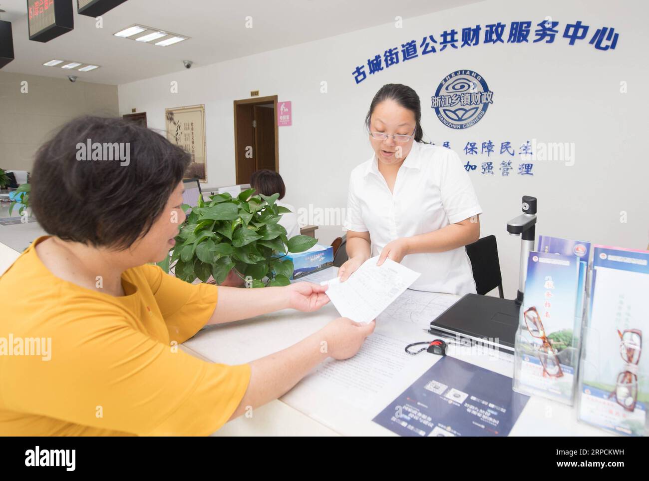 (190708) -- LINHAI, 8 de julio de 2019 -- Fang Huafen (izq.), un funcionario de la comunidad de Lucheng, solicita un fondo de ayuda para Wu Yuanmiao en un centro de servicio en la ciudad de Linhai, provincia de Zhejiang, al este de China, el 27 de junio de 2019. Wu Yuanmiao, cuando trabajaba como peluquero, estableció una regla para sí mismo para proporcionar servicio gratuito un día a la semana a los ancianos, los discapacitados y los soldados. Después de haber servido a más de 60.000 clientes durante 17 año, es el ganador de varios premios, incluida la Medalla Laboral de mayo de 1. Sin embargo, diagnosticada con enfermedad cerebral, la condición de Wu ha estado peor desde 2008. En 2014, experimentó un tiempo difícil en el correr Foto de stock