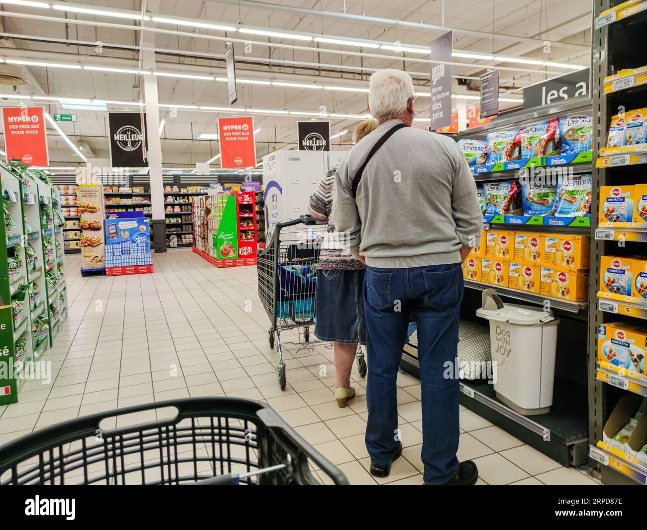 Puilboreau, Francia - 14 de octubre de 2020: Comprador que selecciona comida para perros en el pasillo de la tienda de mascotas Foto de stock