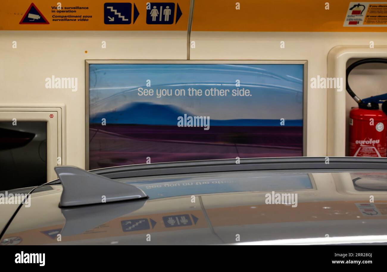 Un cartel que dice 'nos vemos en el otro lado' sobre el techo de un coche cargado en el tren Eurotunnel conocido como Le Shuttle utilizando el túnel del canal de fo Foto de stock
