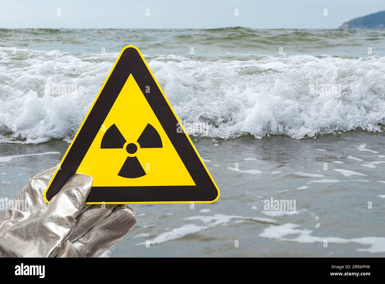 señal de advertencia de radiación nuclear frente a una composición horizontal oceánica Foto de stock