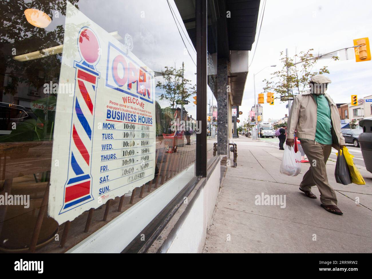 210630 -- TORONTO, 30 de junio de 2021 -- Un hombre pasa por delante de una peluquería con un cartel ABIERTO en su ventana en Toronto, Ontario, Canadá, el 30 de junio de 2021. La provincia canadiense de Ontario permitió que la mayoría de las regiones reabrieran más negocios el miércoles, ya que avanzaron al paso dos del plan de reapertura de la provincia, incluyendo peluquerías, salones de uñas y tiendas en centros comerciales. Foto por /Xinhua CANADA-ONTARIO-COVID-19-REOPENING-STEP TWO ZouxZheng PUBLICATIONxNOTxINxCHN Foto de stock