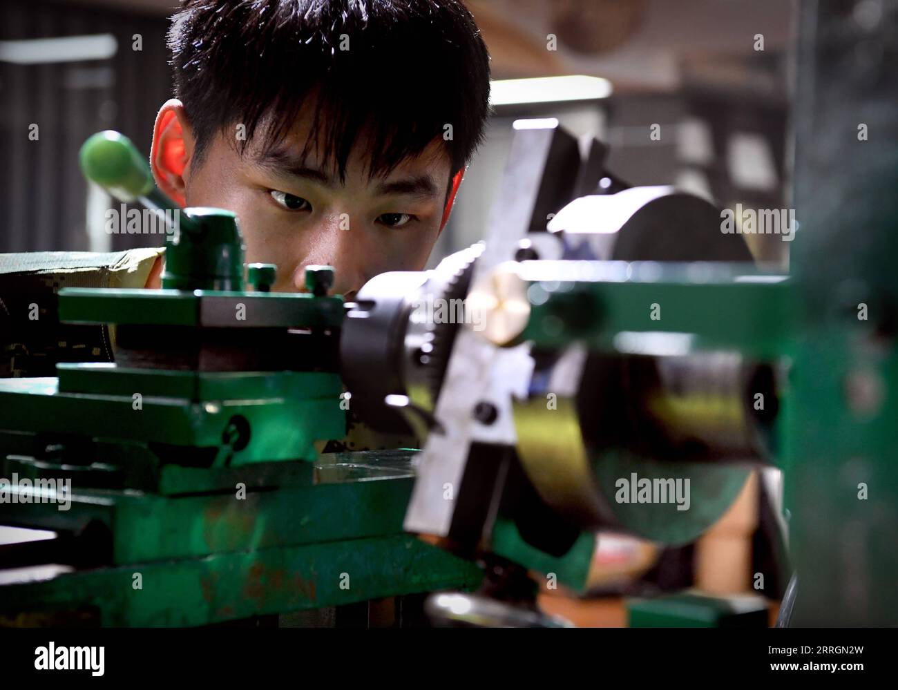220527 -- XINMI, 27 de mayo de 2022 -- El aprendiz de Cheng Yucai Li Jinghang ajusta la máquina de guilloche en el taller de Cheng en la ciudad de Xinmi, provincia central de Henan, China, el 24 de mayo de 2022. El guilloche es una técnica decorativa en la que un patrón preciso, intrincado y repetitivo se graba mecánicamente en un material a través del giro del motor. La técnica utiliza una máquina controlada por la delicadeza de la mano del artesano. Como un proceso importante en la fabricación de relojes y joyas superiores, el arte ahora es dominado por pocas personas. Cheng Yucai, nacido en 1978, conoció a Guilloche en 2013 cuando vio un cigarro Foto de stock
