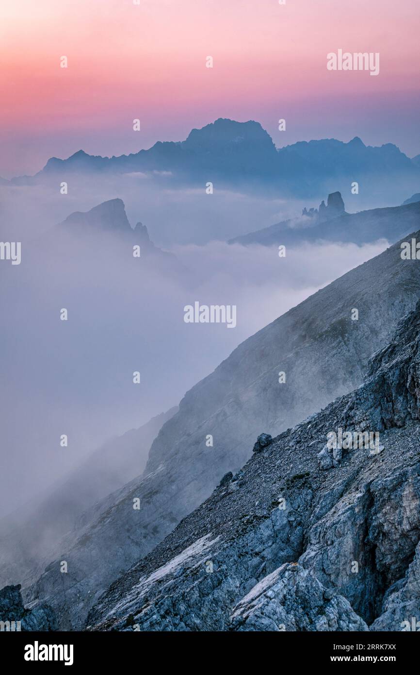 Italia, Véneto, provincia de Belluno, Dolomitas, montañas en una bruma mañana de verano, vista desde la cima de una montaña Foto de stock