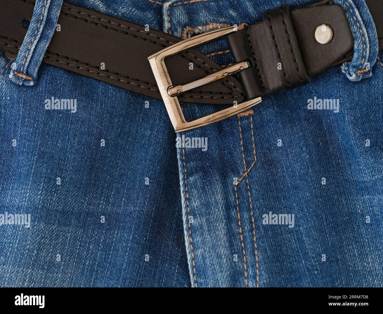 Jeans azules y un cinturón de cuero. Primer plano. Foto de stock