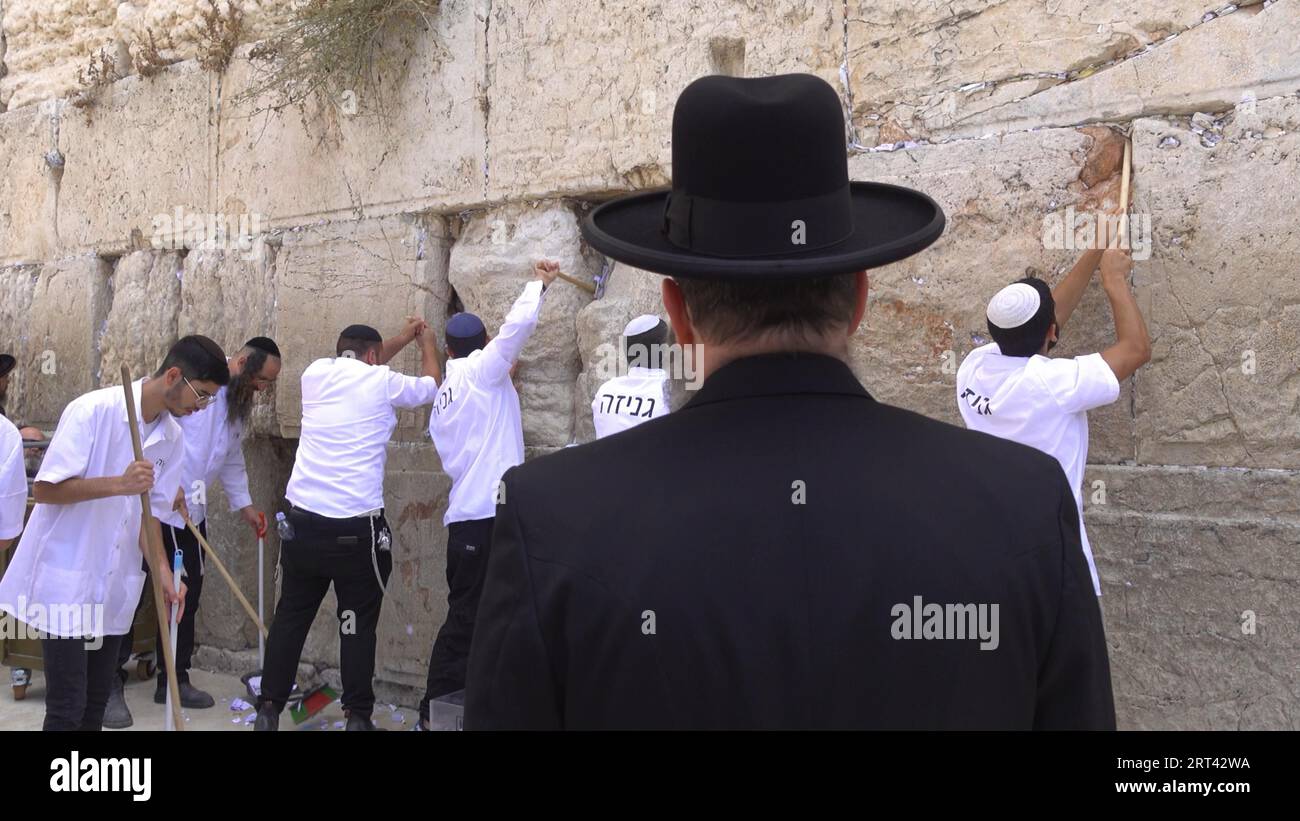 Los empleados del Muro Occidental retiran notas a Dios y oraciones, escritas en trozos de papel que han sido colocadas entre las piedras del Muro Occidental por los visitantes durante los últimos meses en preparación para el próximo Año Nuevo Judío Rosh Hashanah el 10 de septiembre de 2023 en Jerusalén, Israel. Dos veces al año, antes de la Pascua y el Año Nuevo Judío, las notas son removidas y enterradas en un lugar específicamente designado para esto en el Monte de los Olivos. Foto de stock