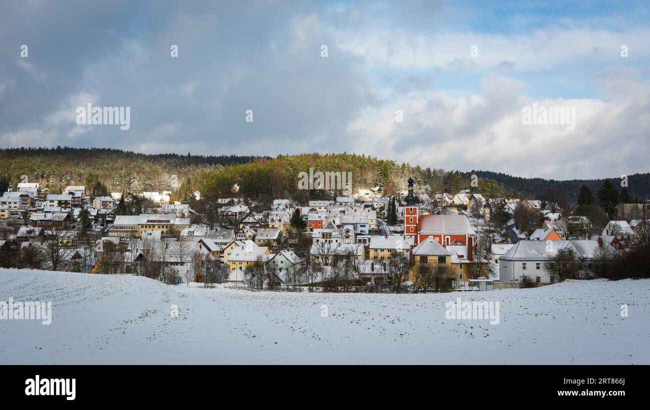 Vista panorámica de la pequeña ciudad de Etzelwang en Baviera con techos cubiertos de nieve y la iglesia en el soleado día de invierno Foto de stock