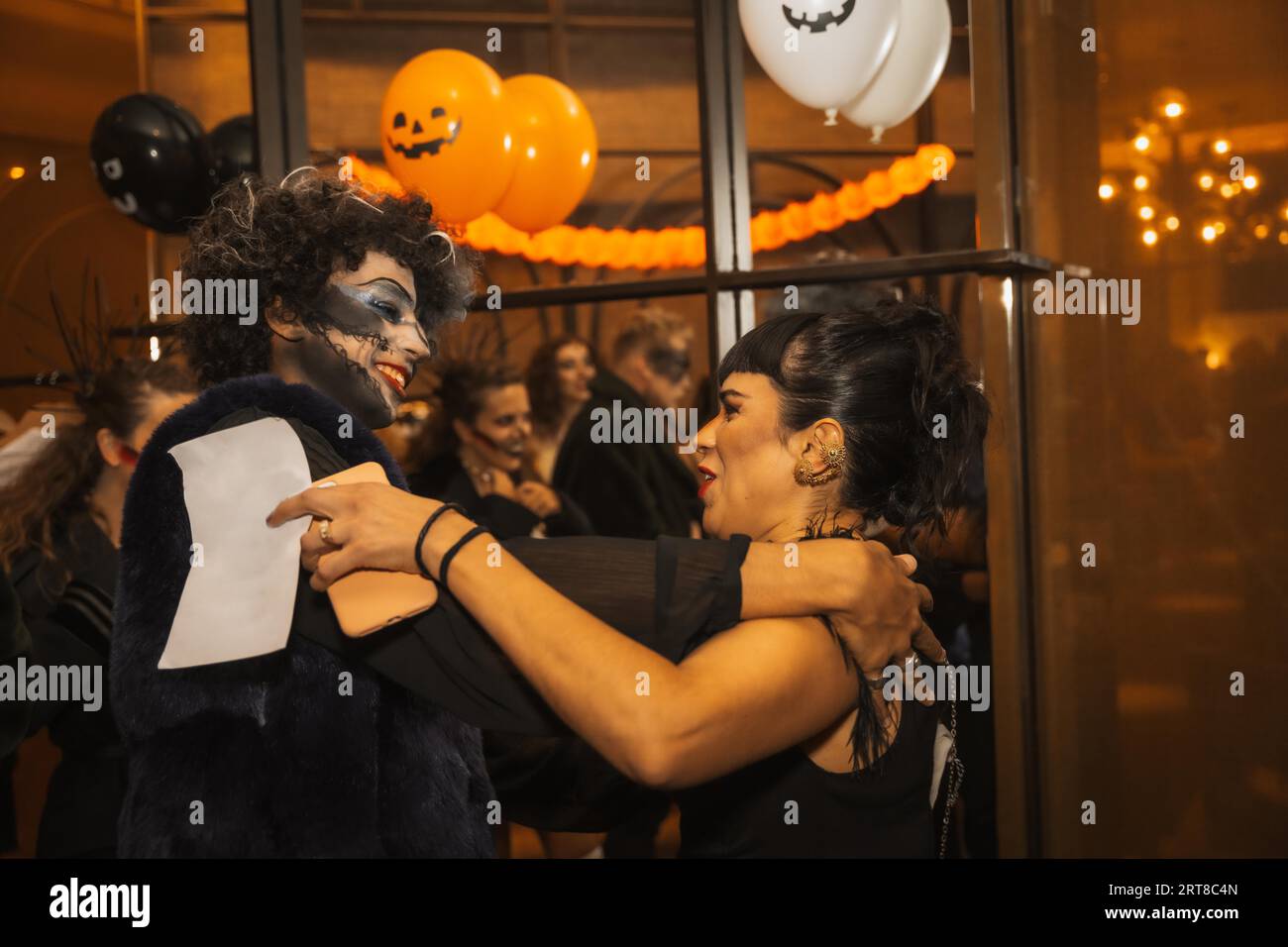 Fiesta de Halloween con amigos en una discoteca, dos amigos se saludan en la fiesta Foto de stock