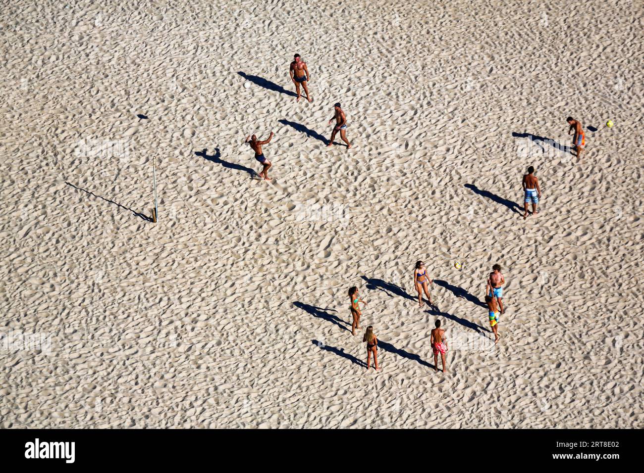 Voleibol de playa en la playa de Nazare, los jugadores proyectan largas sombras, vista desde arriba, Portugal Foto de stock
