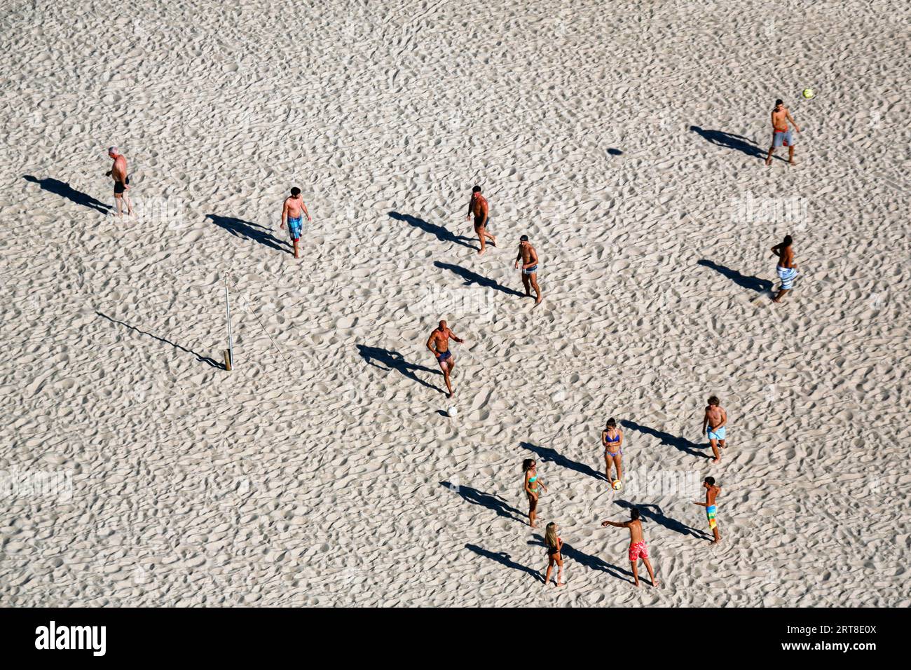 Voleibol de playa en la playa de Nazare, los jugadores proyectan largas sombras, vista desde arriba, Portugal Foto de stock