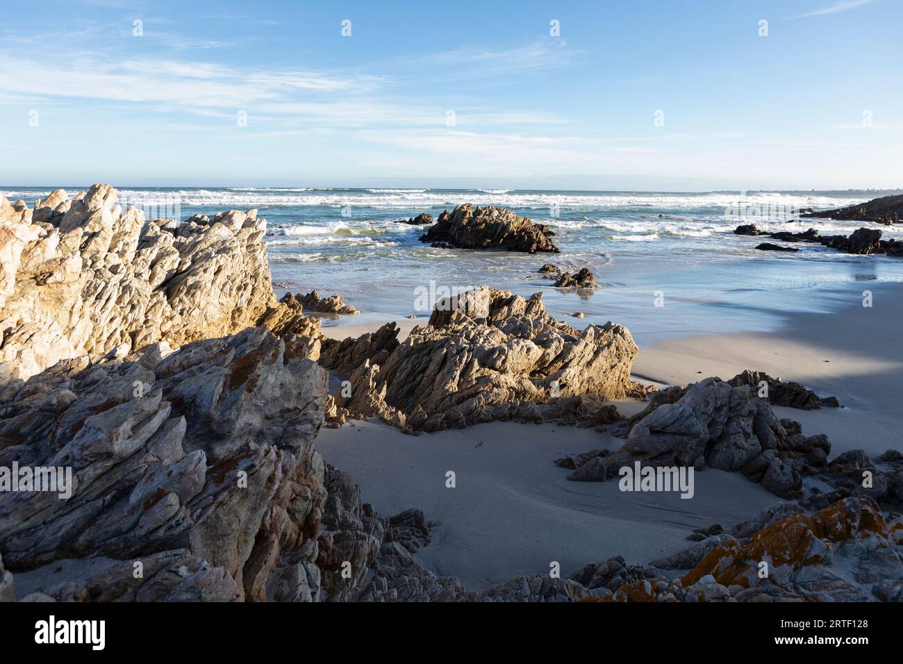 Sudáfrica, Hermanus, Costa rocosa con el océano Atlántico en Voelklip Beach en el día soleado Foto de stock