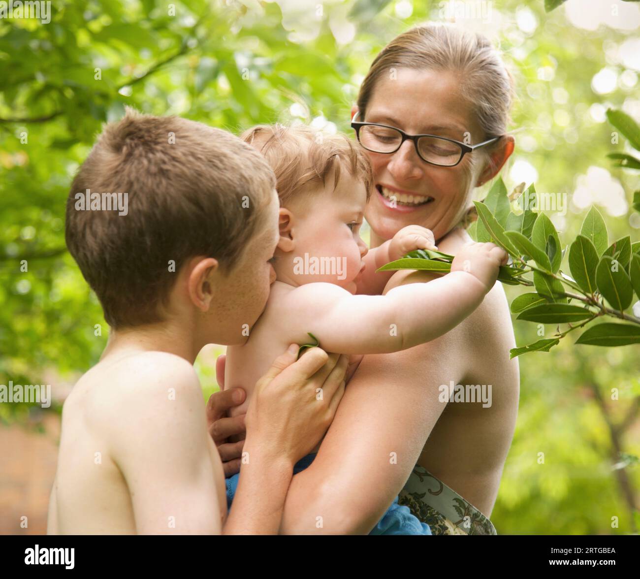 Familia de pie en un jardín abrazando Foto de stock