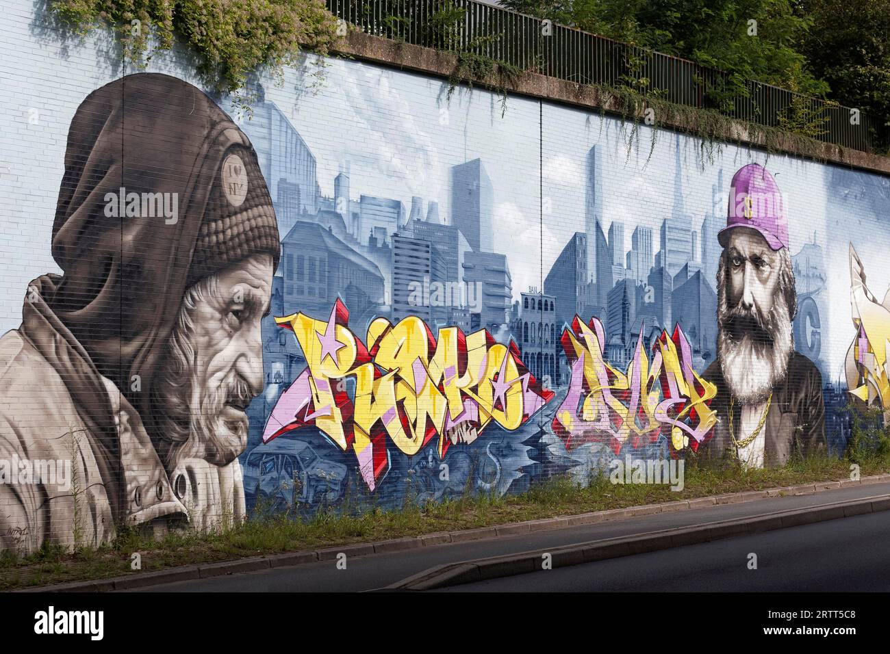 Hombre sin hogar y Karl Marx en yuxtaposición, retratos frente al horizonte de la gran ciudad, mural socialmente crítico por los artistas callejeros INTRO y DOE Foto de stock