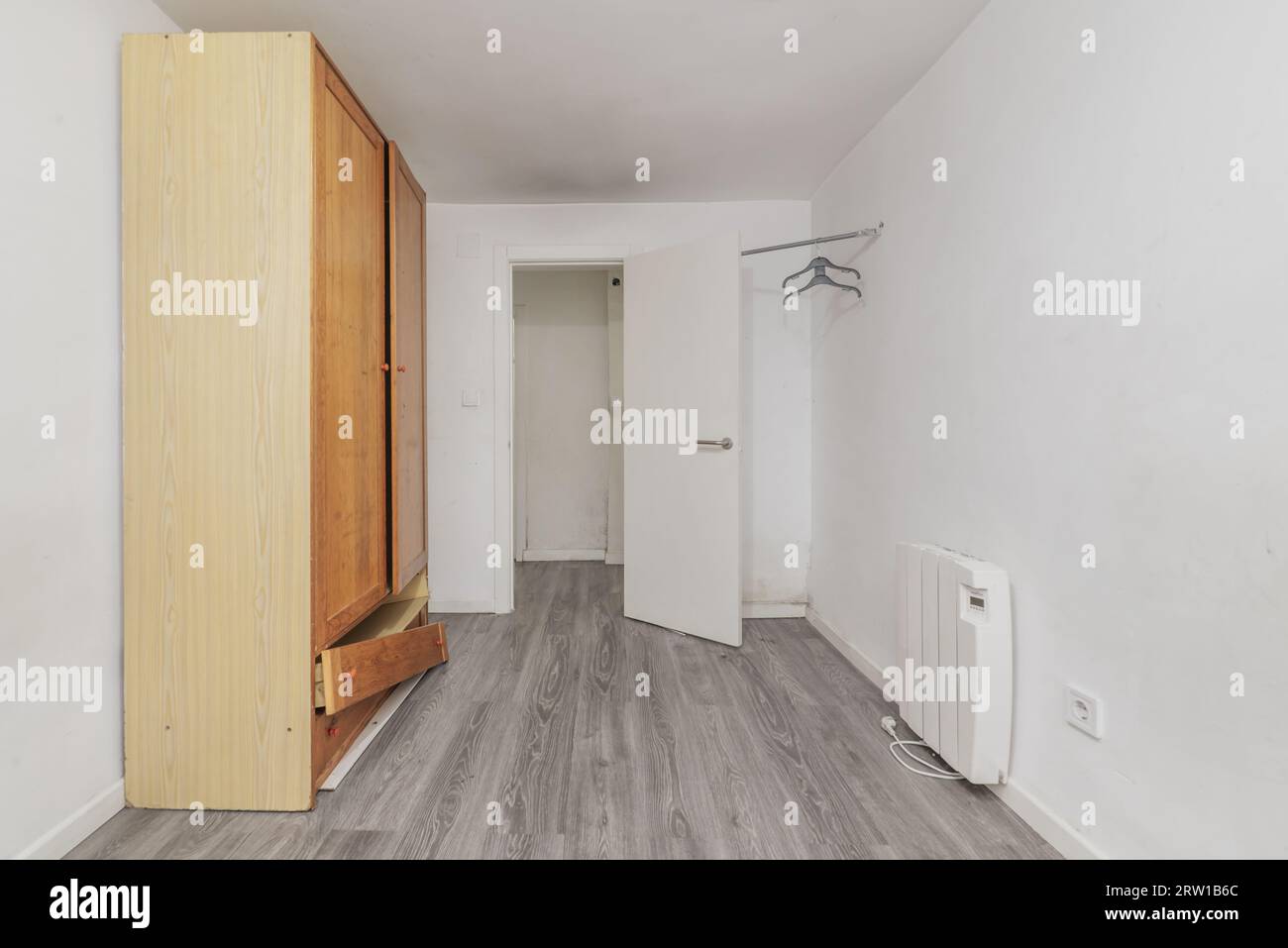 habitación vacía con un armario desvencijado, radiador eléctrico y paredes  blancas planas Fotografía de stock - Alamy