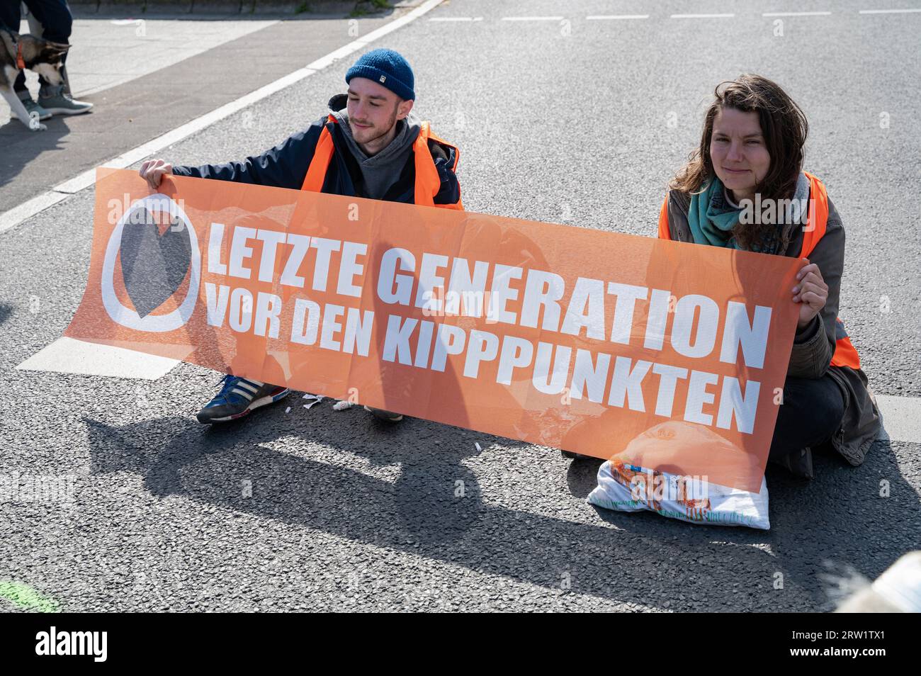 28.04.2023, Alemania, Berlín, Berlín - Europa - Los manifestantes climáticos de última generación están atrapados en la calzada de una carretera principal en Ernst-Reuter-Platz en Foto de stock