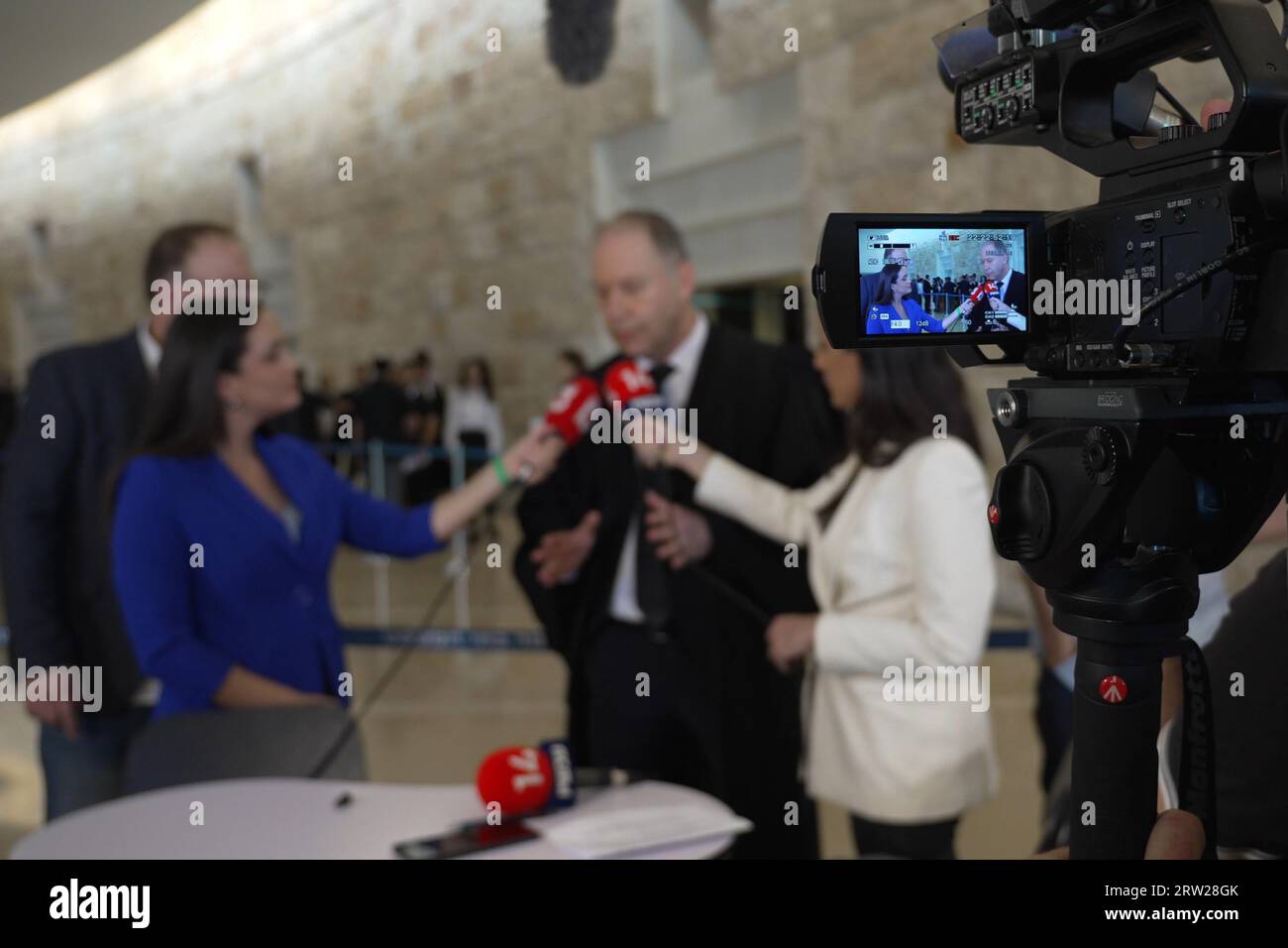 Reporteros de televisión de canales de televisión israelíes entrevistan a Ilan Bombach, un abogado privado que representa al gobierno en la audiencia del Tribunal Superior sobre la ley de razonabilidad, mientras quince jueces de la Corte Suprema se reúnen para escuchar peticiones contra el 'proyecto de ley de razonabilidad' del gobierno en el Tribunal Supremo el 12 de septiembre de 2023 en Jerusalén, Israel. El estándar de razonabilidad es una doctrina de derecho común que permite a los tribunales llevar a cabo revisiones judiciales de las decisiones administrativas del gobierno que van mucho más allá de lo que una autoridad razonable y responsable haría. Foto de stock