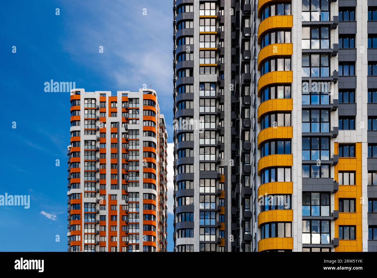 edificios de apartamentos de gran altura recién construidos sobre fondo de cielo azul con nubes blancas. Foto de stock