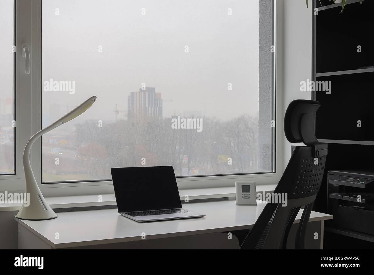 Escritorio de madera con ordenador portátil, pantalla, ratón, lámpara,  silla ergonómica y árbol artificial en el lugar de trabajo del dormitorio  Fotografía de stock - Alamy