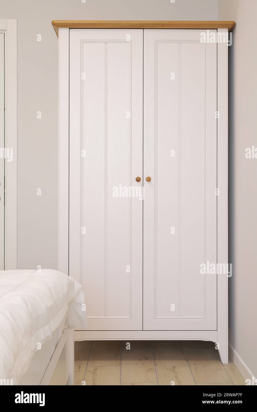 Dos perchas blancas están en ganchos cerca de la pared de madera en blanco,  foto de fondo vertical Fotografía de stock - Alamy