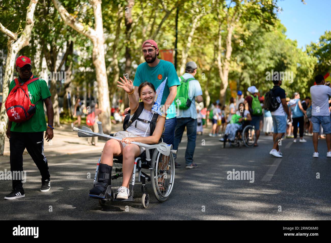 Una niña en silla de ruedas en su camino a la Santa Misa de apertura en el Parque Eduardo VII en el primer día de las Jornadas Mundiales de la Juventud 2023 en Lisboa, Portugal. Foto de stock