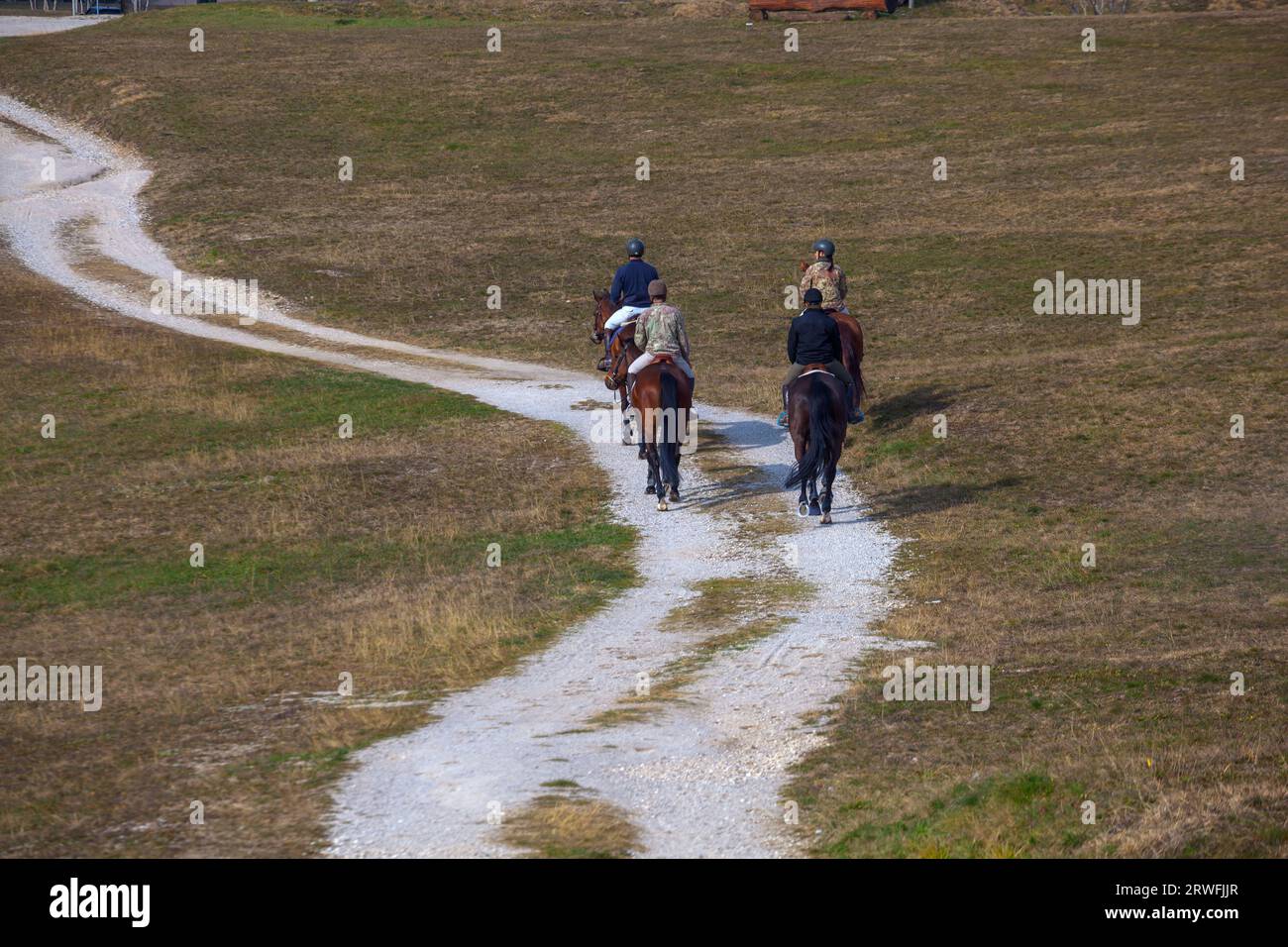 Los jinetes exploran con gracia los bastiones de Palmanova, mezclando la aventura ecuestre con la cautivadora belleza de los alrededores Foto de stock