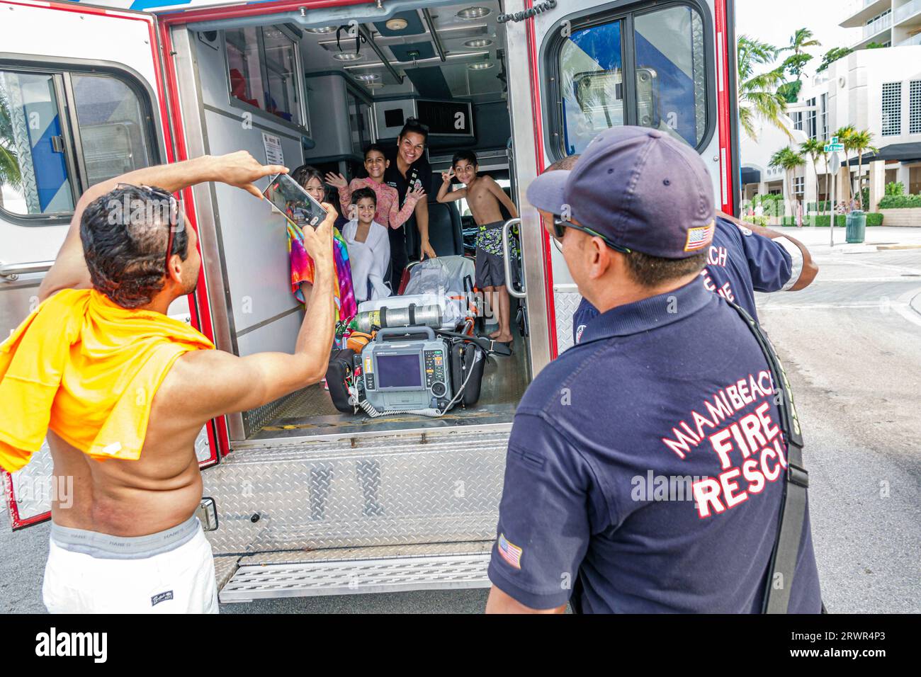 Miami Beach Florida, ambulancia de rescate de incendios en el interior de turismo posando tomando foto, familias de la familia padres padre madre, hijo hija niña, hispano Foto de stock
