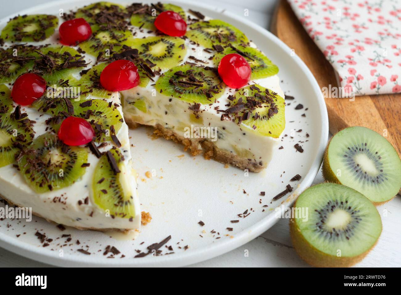 Rubi y pastel de kiwi con una base de galleta decorada con chocolate rallado. Foto de stock