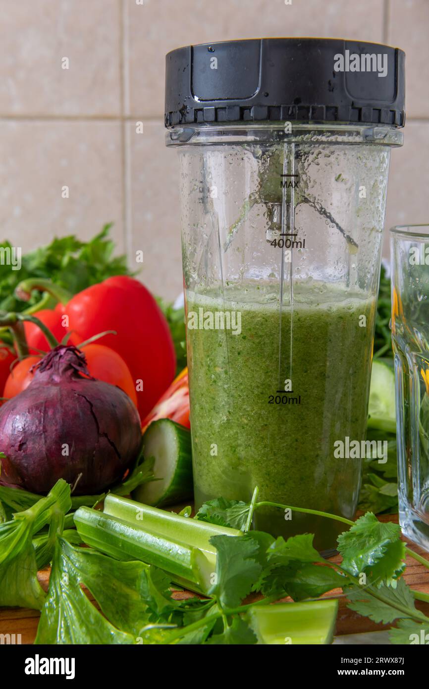 Hacer batido de verduras con verduras frescas en una licuadora. Alimentos saludables y concepto de vida. Foto de stock