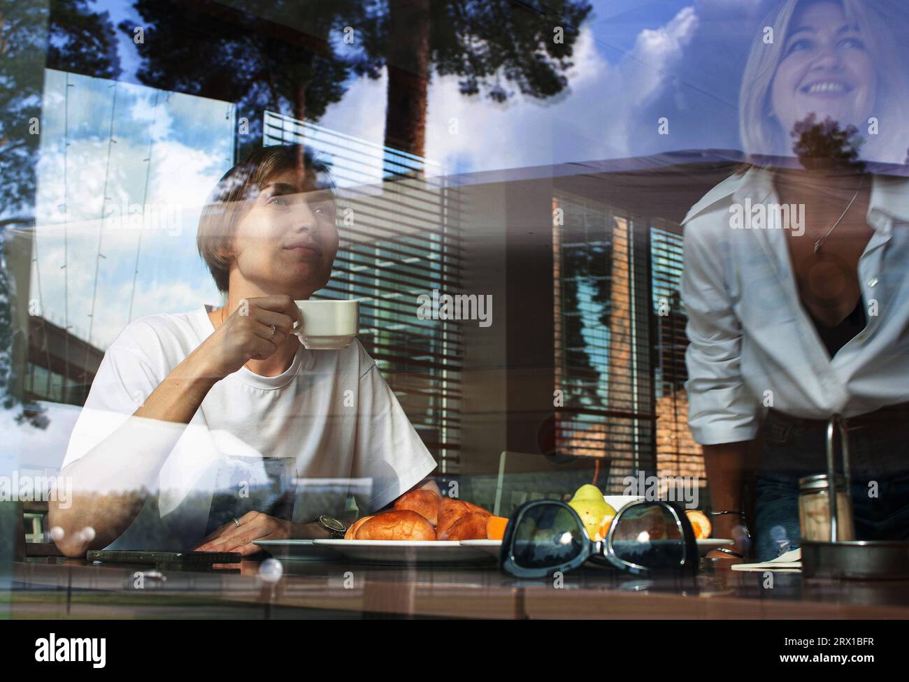 dos mujeres bonitas de 35-40 años de edad están desayunando en un café, Foto de stock