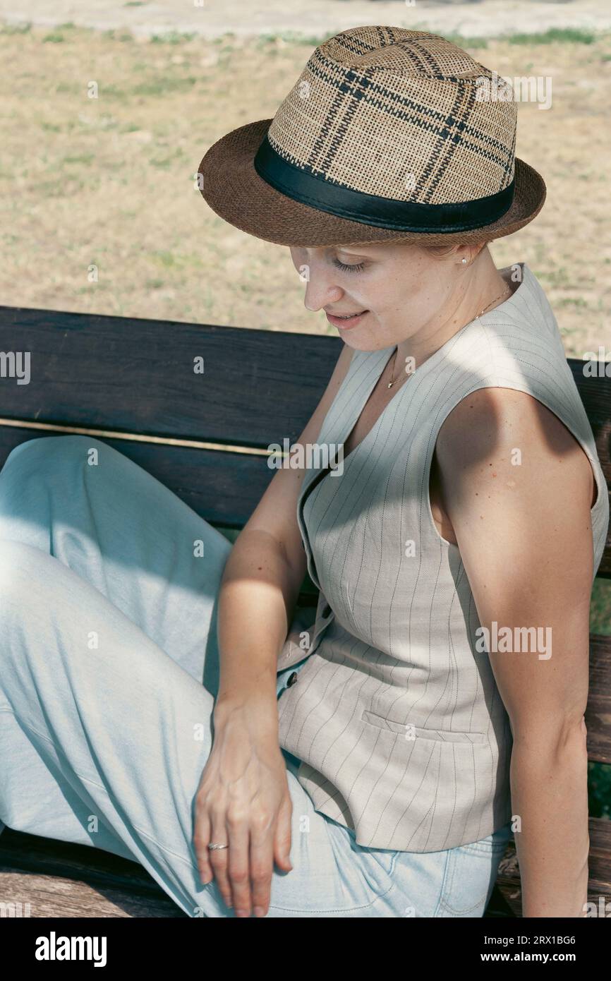 Mujer vistiendo un chaleco y sombrero de paja Fotografía de stock