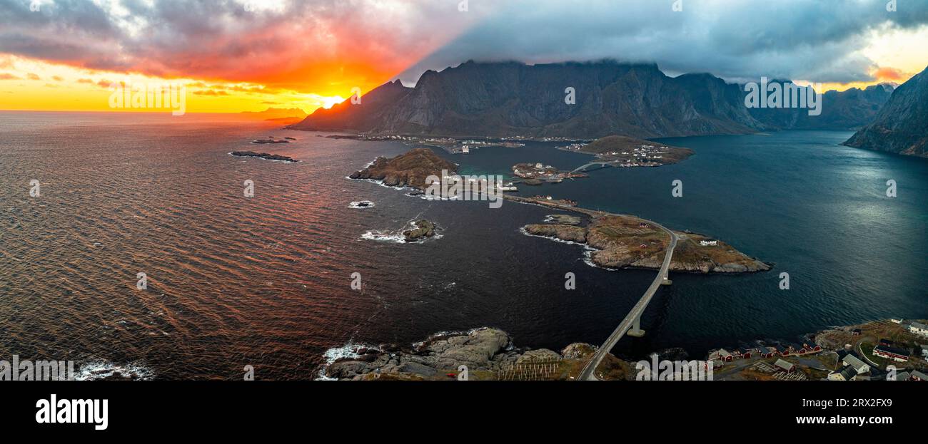 Vista panorámica aérea de la bahía de Reine y el fiordo bajo un cielo ardiente al atardecer, Islas Lofoten, Nordland, Noruega, Escandinavia, Europa Foto de stock