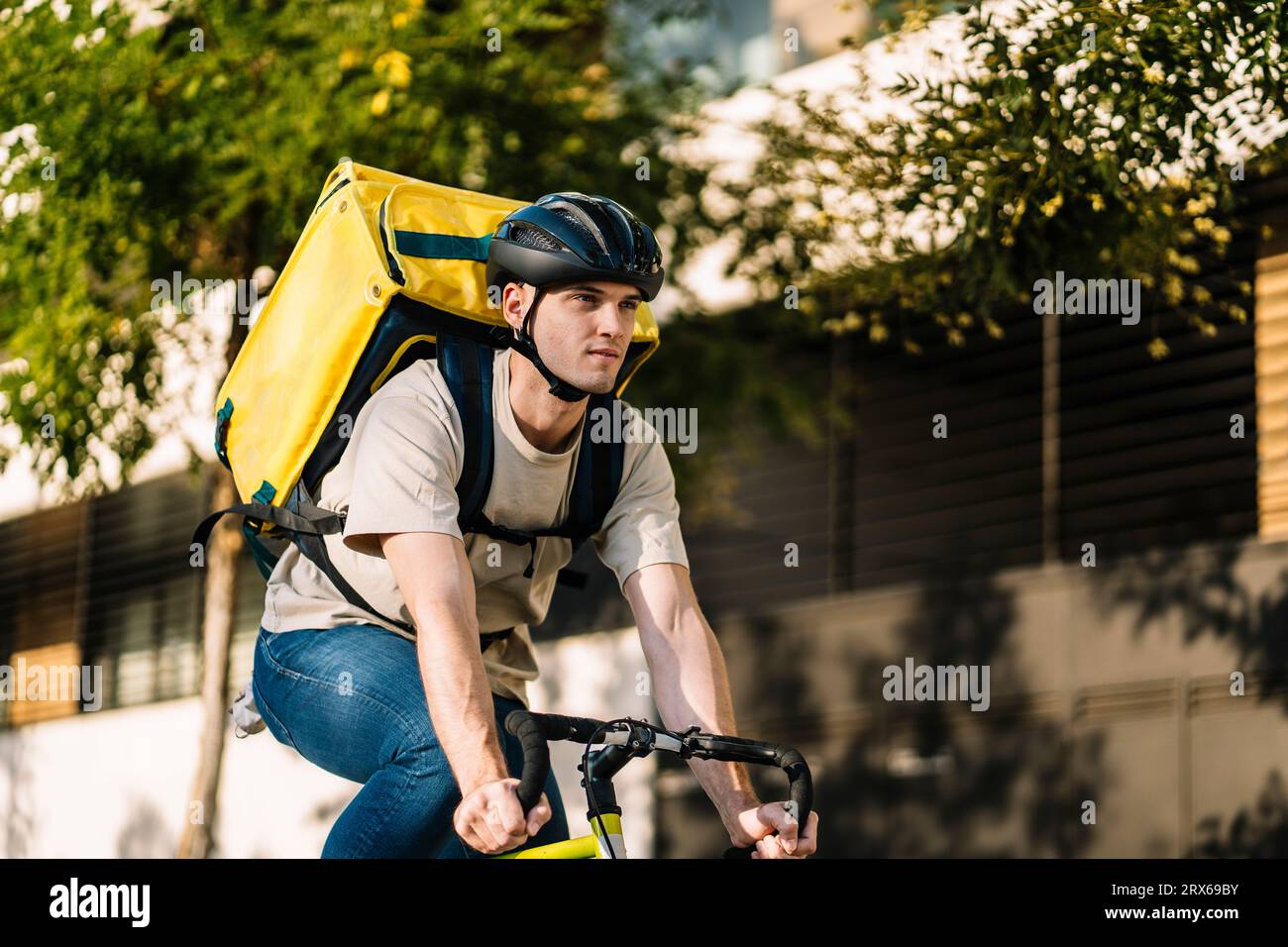 Persona de entrega con bolsa montando bicicleta Foto de stock