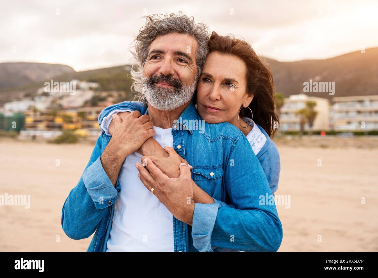 Mujer mayor abrazando al hombre desde atrás en la playa Foto de stock