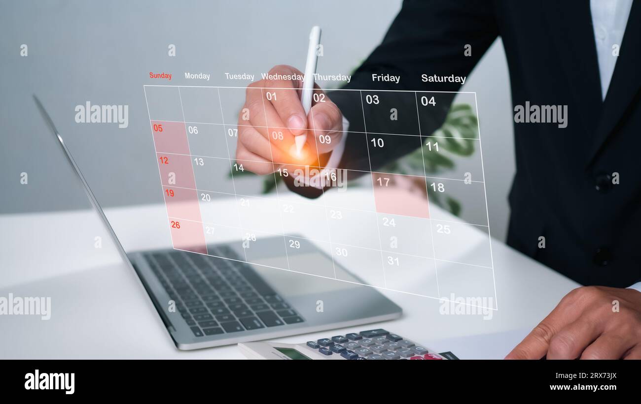Empresario marcando fechas en calendario virtual, administrando su