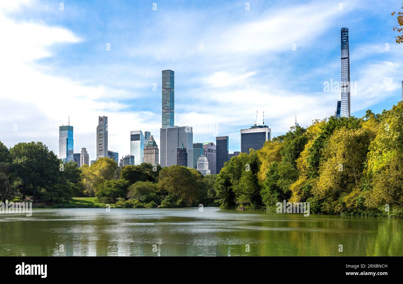 Rascacielos y edificios del centro de Manhattan, incluyendo la Torre Steinway y la Torre Central Park en un pintoresco paisaje con vistas al lago Foto de stock