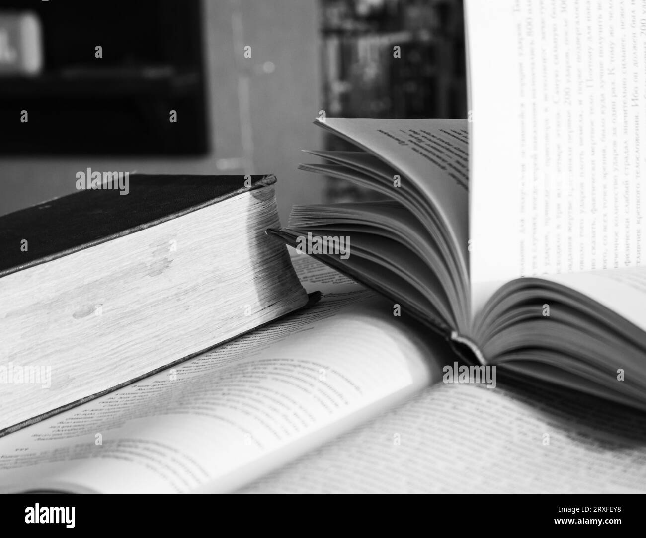 Libros abiertos sobre una mesa, en blanco y negro. Antecedentes de la literatura. Conocimiento en las páginas. Fondo de biblioteca. Hobby y ocio. Concepto de educación. Foto de stock