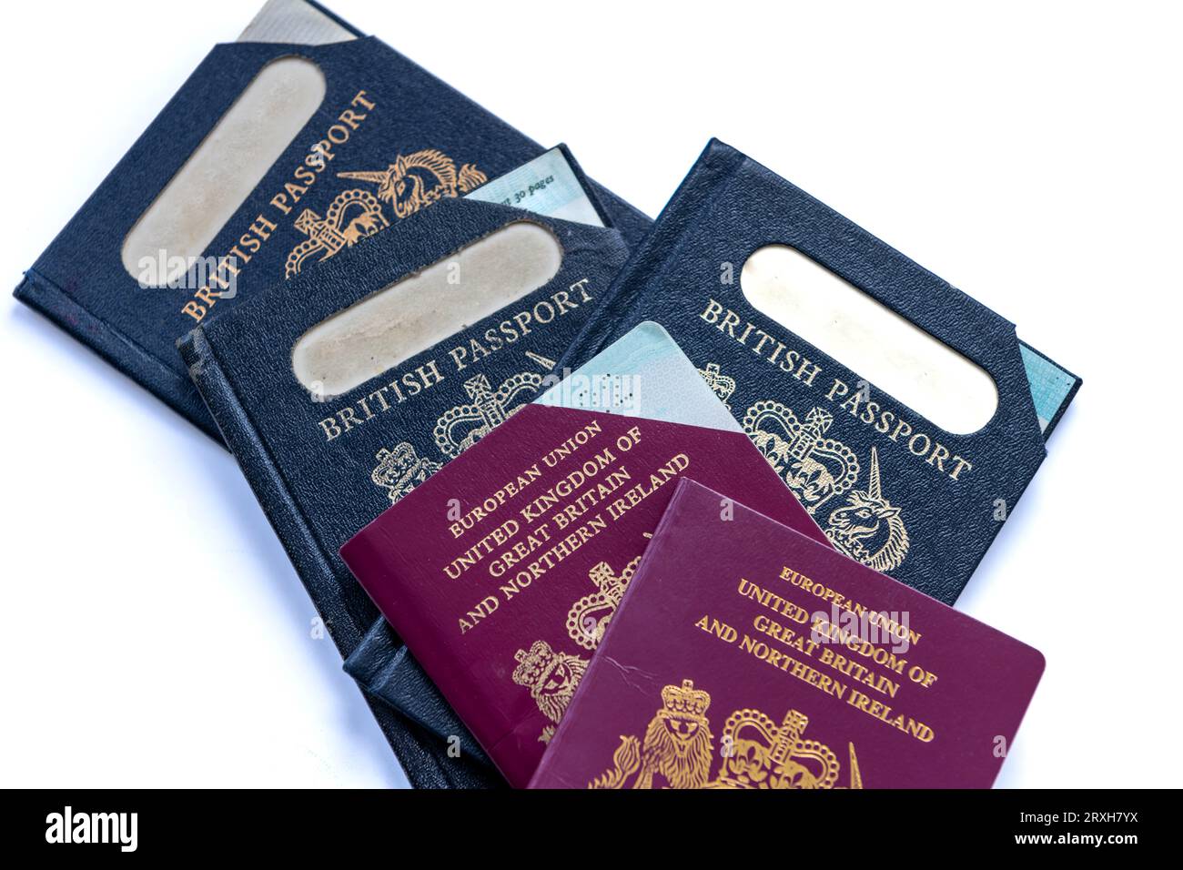 Cierre del pasaporte británico caducado y actual que abarca cincuenta años aislado en un fondo blanco. Foto de stock