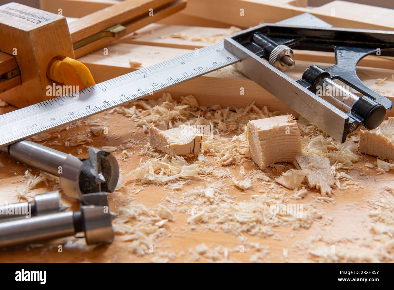Madera, virutas de madera y herramientas de carpintería en un banco de trabajo. Foto de stock