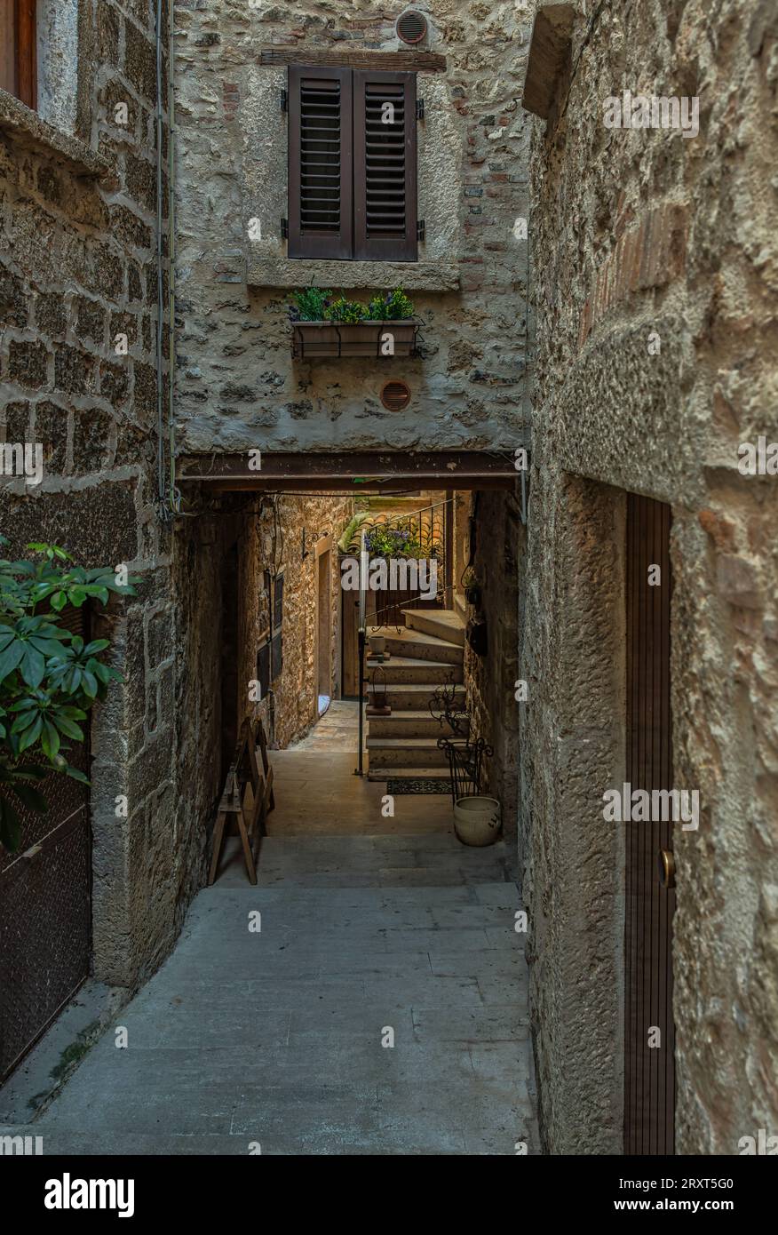 Callejones y escaleras entre casas de piedra y coloridas cajas de flores en el pueblo medieval de Castel Trosino. Ascoli Piceno, Región de las Marcas, Foto de stock