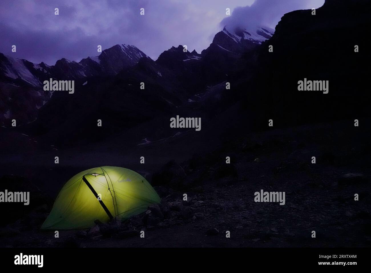 La tienda de Trekker se iluminó en el interior por la noche en las remotas y espectaculares montañas Fann, parte del oeste de Pamir-Alay, Tayikistán, Asia Central, Asia Foto de stock